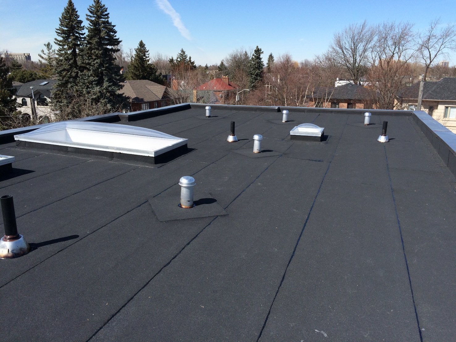 Modified-bitumen flat roof with vents and skylight